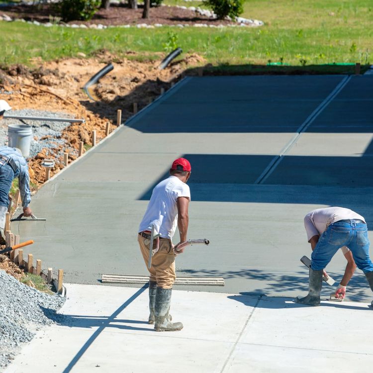 People Pouring and Evening New Concrete Driveway